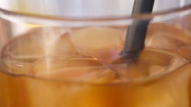 Şeffaf bardakta taze siyah pipetli buzlu Americano kahvesi..