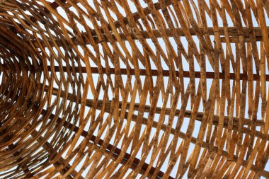 Mavi bir gökyüzü ve gün ışığında sahilde samandan yapılmış bir plaj şemsiyesi..