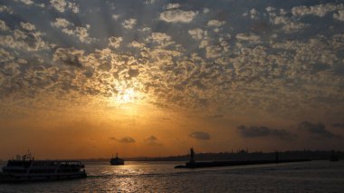 Bulutlu bir gün batımında bir direğin yanında bir insanın siluetinin yakın çekim görüntüsü..