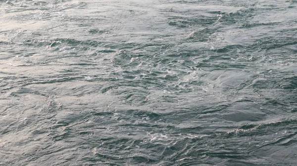 Close-up of the gentle waves of the calm sea in daylight.