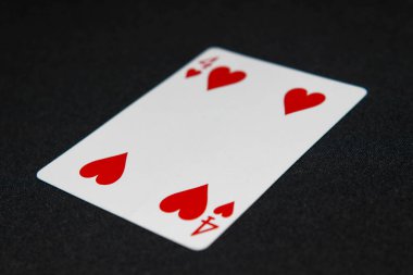 Parlak ışıklandırmanın altında siyah kadife bir arkaplan karşısında toplanabilir iskambil kağıtlarının detaylı bir yakın çekimi.