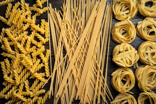 Pasta Shapes Spaghetti Fusilli Tagliatelle Italian Cuisine Ingredients Wooden Background — Stock Photo, Image