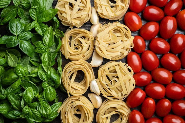 Flag of Italy made of fresh Italian cuisine ingredients, basil leaves, tagliatelle pasta, garlic, and tomatoes