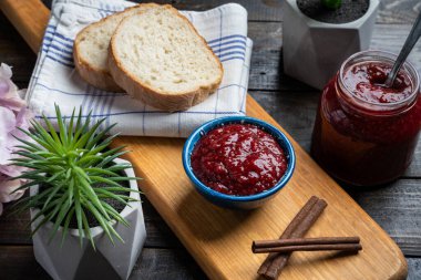 Taze ev yapımı ahududu reçeli ahşap bir tabakta, ekmek ile servis edilir.
