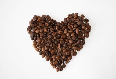Kalp şeklinde kahverengi kahve çekirdekleri beyaz arka planda izole edilmiş. Kopyalama alanı olan kalp hakkında masaüstü fikri.