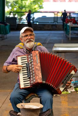 Yaşlı bir adam pazarda akordeon çalıyor. Bu pazar Türkçe 