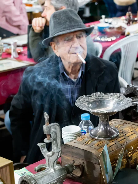 Yaşlı bir adam, çarşıda sigara içiyor. Bu pazar Türkçe 