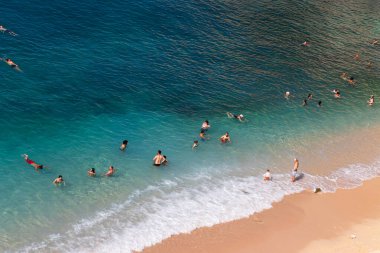 Plajda yaz. Mavi ve dalgalı denizlerdeki insanlar Yazın güzel kumlarla.