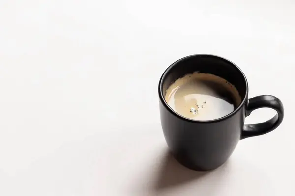 Metin için fotokopi alanı olan siyah bir fincan kahvenin üst görüntüsü. Modern düz yatak. Beyaz arkaplan.