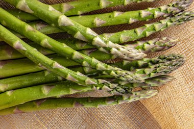 Tahta bir masada taze yeşil kuşkonmaz.