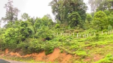 Bhutan 'da bulutlu bir günde dağların çevresi yeşilliklerle çevrili.