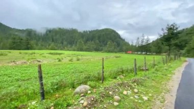 Bhutan 'da bulutlu bir günde dağların çevresi yeşilliklerle çevrili.