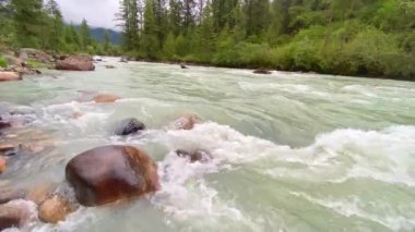 Bhutan 'ın Bumthang ilçesinde dağlarla çevrili bir vadide akan bir nehrin manzarası.