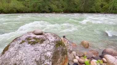 Bhutan 'ın Bumthang ilçesinde dağlarla çevrili bir vadide akan bir nehrin manzarası.