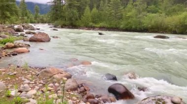 Bhutan 'ın Bumthang ilçesinde dağlarla çevrili bir vadide akan bir nehrin manzarası.