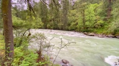 Bhutan 'ın Bumthang ilçesinde dağlarla çevrili bir vadide akan bir nehrin manzarası.