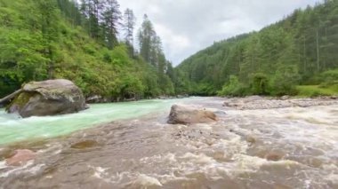 Bhutan 'ın Bumthang ilçesinde dağlarla çevrili bir vadide buluşan iki nehrin manzarası.