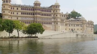 Hindistan 'ın Rajasthan kentindeki Udaipur gölündeki bir tekneden alınan güzel geleneksel saray binalarının manzarası..