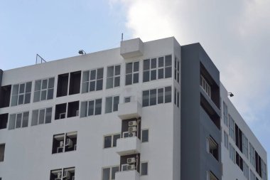 Klimalı ve pencereli beyaz bir bina.