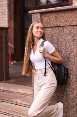 Mutlu bir öğrenci, arkadaşlarıyla çalıştıktan ve sohbet ettikten sonra bir üniversitenin yakınındadır. Bir fincan kahve ve poşeti alıyor..