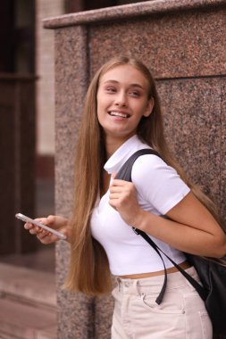 Mutlu bir öğrenci, arkadaşlarıyla çalıştıktan ve sohbet ettikten sonra bir üniversitenin yakınındadır. Bir fincan kahve ve poşeti alıyor..