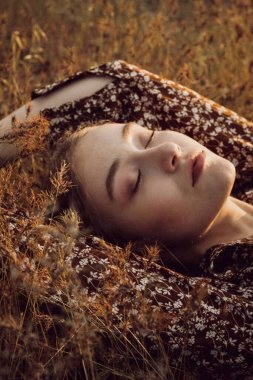 Kadın güzel, sakin bir ormanda çimlerin üzerinde uzanıyor ve temiz hava soluyor..