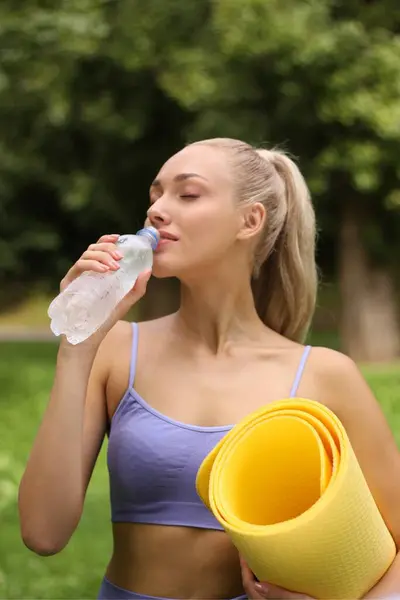 夏日带着瑜伽垫和一瓶水在公园里的年轻女人 她在做运动 — 图库照片