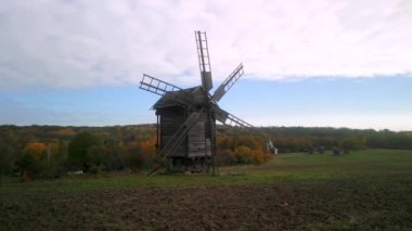 Sonbahar günü Kiev Ukrayna 'daki Pirogovo parkındaki eski ahşap yel değirmenine insansız hava aracı uçuşu.