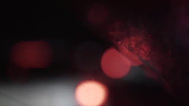 Geceleri araba ve trafik ışıklarıyla dolu bir Bokeh. Küçük Avrupa Şehir Gece Trafiği Bokeh 'i. Şehir caddesindeki trafik sıkışıklığında araba ışıkları yuvarlak renkli bokeh parlıyor. Titrek 4k görüntü