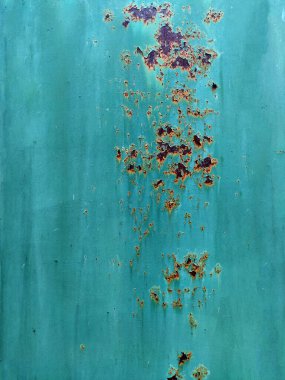 Paslı renkli boyanmış metal duvar. Paslı metal arka planda pas izleri var. Aşınmış metal zemin. Pas lekeleri. Metal yüzey paslanmış lekeler. Paslanmış aşınma.