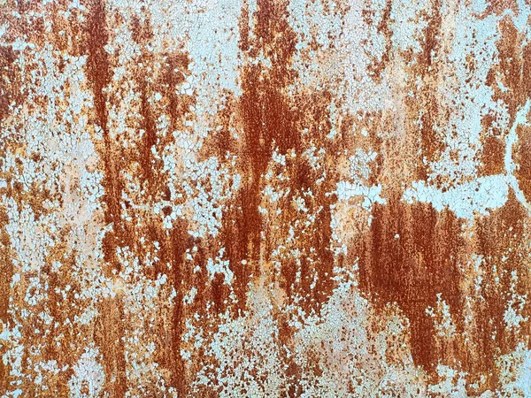 Corroded metal background. Rusted white painted metal wall. Rusty metal background with streaks of rust. Rust stains. The metal surface rusted spots. Rusty corrosion.