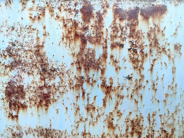 Rusted colorful painted metal wall. Rusty metal background with streaks of rust. Corroded metal background. Rust stains. The metal surface rusted spots. Rusty corrosion.