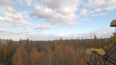 Ukrayna 'nın Pripyat yasaklama bölgesindeki Chornobyl eğlence parkında terk edilmiş dönme dolabın hava manzarası. İnsansız hava aracı dönme dolabın yanından yavaşça geçiyor..