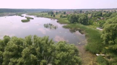 İnsansız hava aracı, Ukrayna 'nın bulutlu bir yaz gününde küçük Avrupa kentindeki küçük göller ve ağaçlarla ortaçağ şatosu ve peyzaj parkının üzerinde uçuyor. 4K hava atışı