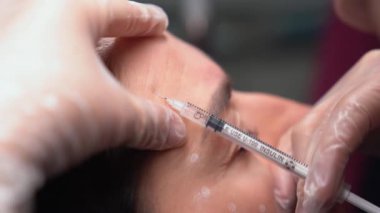 Güzellik uzmanı genç güzel bir kadının alnına botulinyum toksin enjekte ediyor. 4km 'lik atış çok yakın. Güzellik teknolojisi kavramı