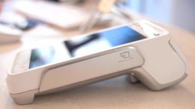 4K yakın çekim videosu. Kadın eli, pos-terminal ve cep telefonuyla. Elektronik ödeme makinesinden ya da kart okuyucudan ödemeyi telefonla yapın. Nakitsiz cüzdanda e-para. Modern güzellikteki prosedür için müşteri ödeme yapar.