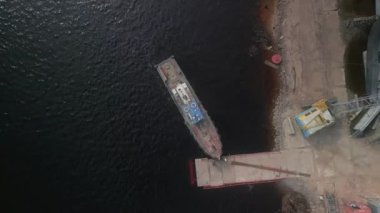 Römorkörün üstündeki hava manzarası nehirdeki inşaat alanının yakınında kalıyor. İnsansız hava aracı kamerası aşağı doğru eğildi. 4k renk düzeltmeli atış. İnsansız hava aracı kamerası aşağı doğru eğildi.