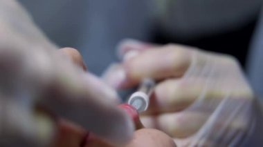 Güzellik uzmanı genç güzel bir kadının dudaklarına botulinyum toksin enjekte ediyor. Renkli 4K atış. Güzellik teknolojisi kavramı