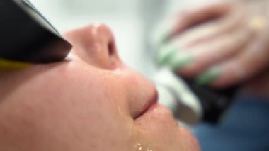 Kadın, güzellik salonunda modern İskenderiye lazer lazer temizleme prosedürüyle karşı karşıya. Kadın güzellik kavramı, kozmetoloji, epilasyon