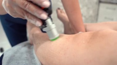 Profesyonel kozmetolojistin, güzellik salonundaki genç bayana, vücut bakımı epilasyonu tedavisinde lazer kılı kesme videosunu kapatın. Güzellik konsepti.