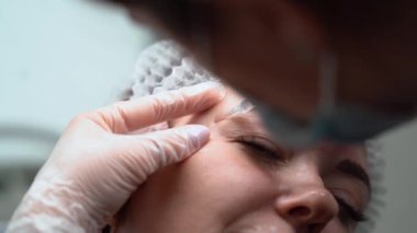 Güzellik uzmanı genç güzel bir kadının alnına botulinyum toksin enjekte ediyor. 4km 'lik atış çok yakın. Güzellik teknolojisi kavramı