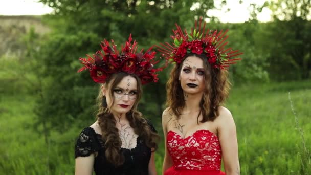 Όμορφες Γυναίκες Μάγισσες Μακρύ Κόκκινο Και Μαύρο Φορέματα Λουλούδια Στεφάνι — Αρχείο Βίντεο