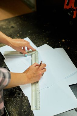 Kadın iç mimar çizimler üzerinde çalışıyor, kadın mimar atölyede yeni daire tasarımı cetvel planı çiziyor, yeni inşaat projesinin tasarım projeleri.