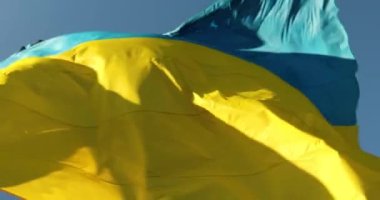 Mavi gökyüzünde rüzgarda dalgalanan büyük Ukrayna bayrağı. Doğu Avrupa ülkesi, vatanseverlik, Ukrayna sarı mavi bayrağı.