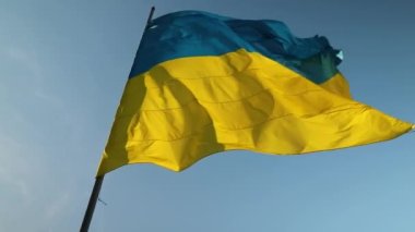Mavi gökyüzünde rüzgarda dalgalanan büyük Ukrayna bayrağı. Doğu Avrupa ülkesi, vatanseverlik, Ukrayna sarı mavi bayrağı.