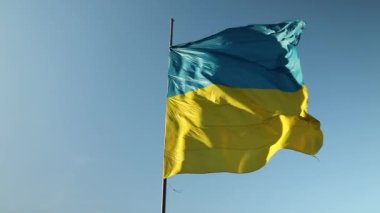 Mavi gökyüzünde rüzgarda dalgalanan büyük Ukrayna bayrağı. Doğu Avrupa ülkesi, vatanseverlik, Ukrayna sarı mavi bayrağı.
