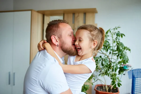 Father and daughter in white spending time at home, handsome man playing with his little cute girl, having fun relaxing spending time together, Happy Father\'s Day.