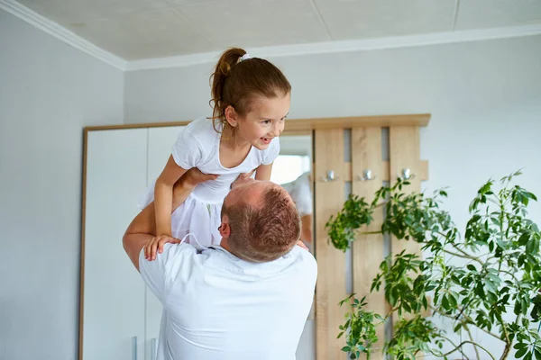 Father and daughter in white spending time at home, handsome man playing with his little cute girl, having fun relaxing spending time together, Happy Father's Day.