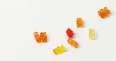 Tasty jelly bears candy falling on white background, flat lay candy gummy bear, copy space.