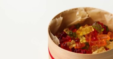 Woman hand take tasty jelly bears candy from present box with on white background, candy gummy bear